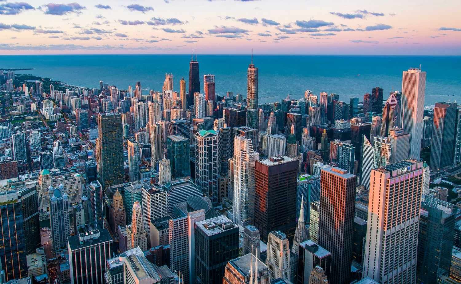 Modern city skyline with glass towers reflecting sunset